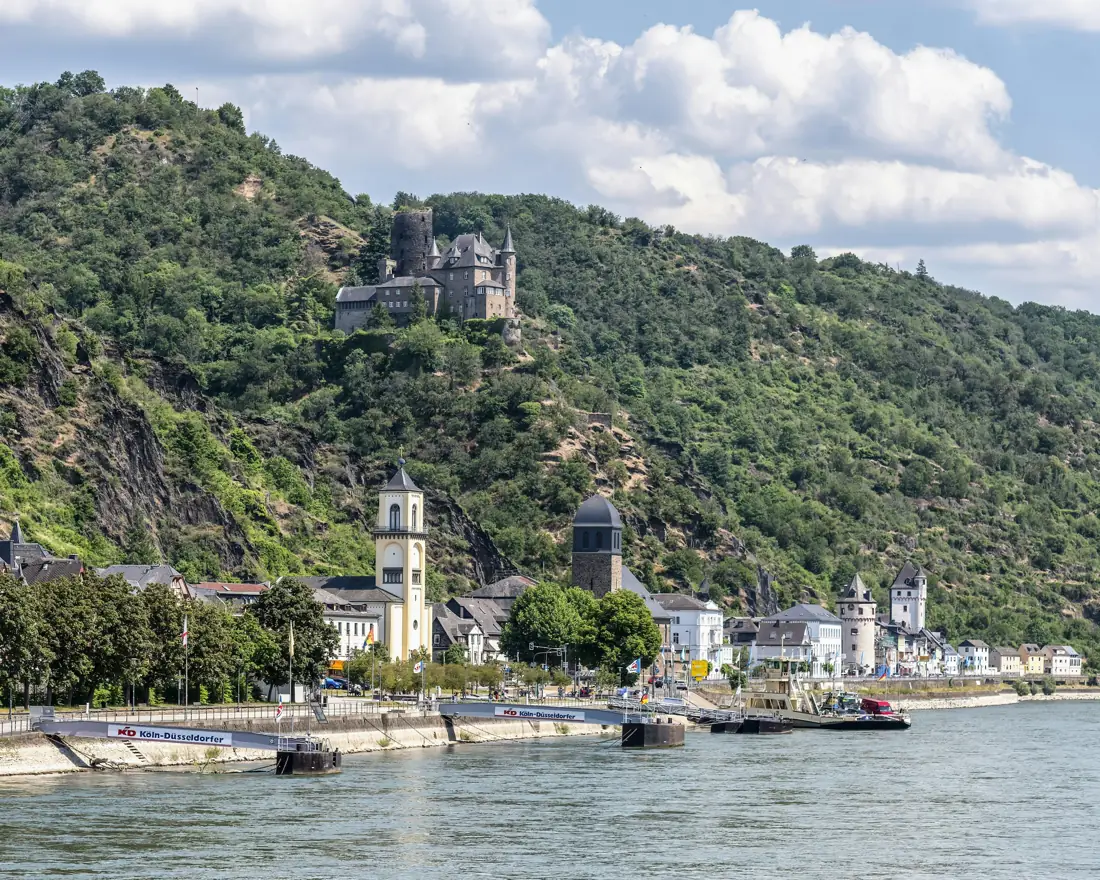 A river winding past a hilltop castle and village in Europe